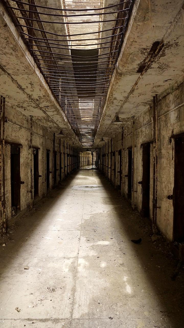 Photographer framing a symmetrical hallway in abandoned hospital